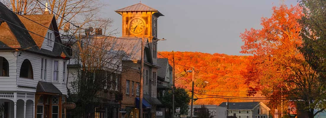 Charming small town street with autumn foliage and clock tower