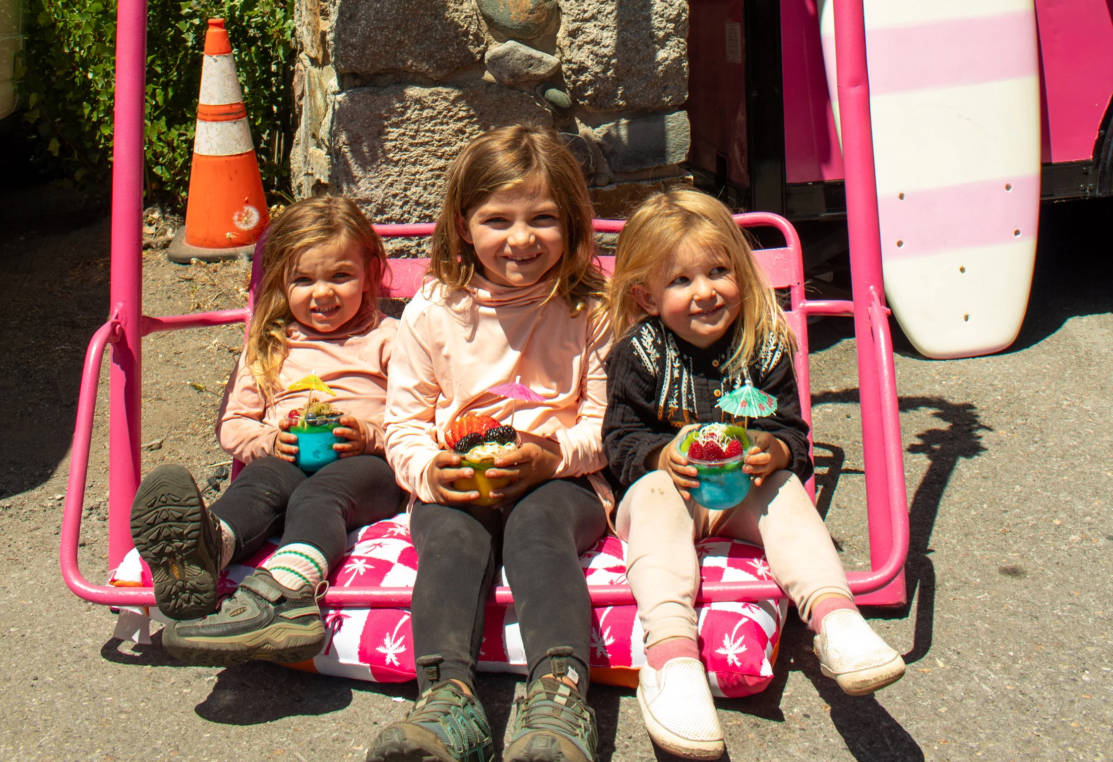 Children enjoying colorful fruit cups on a sunny day