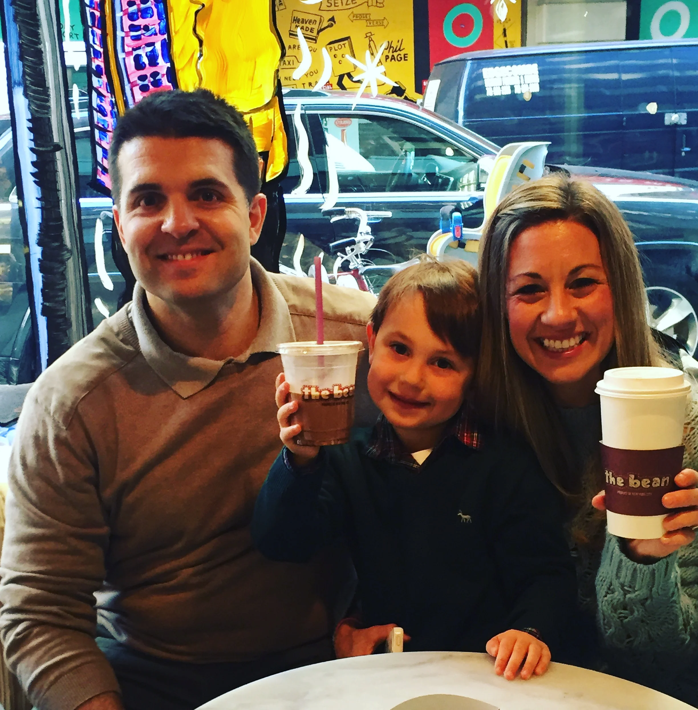 Family enjoying drinks at a vibrant café with colorful decor