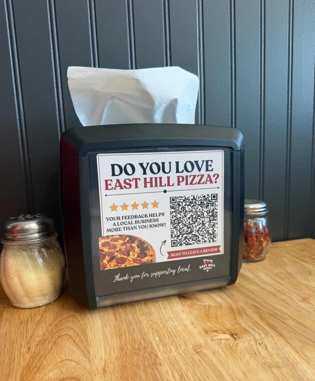 Restaurant table tent with pizza review signage and QR code