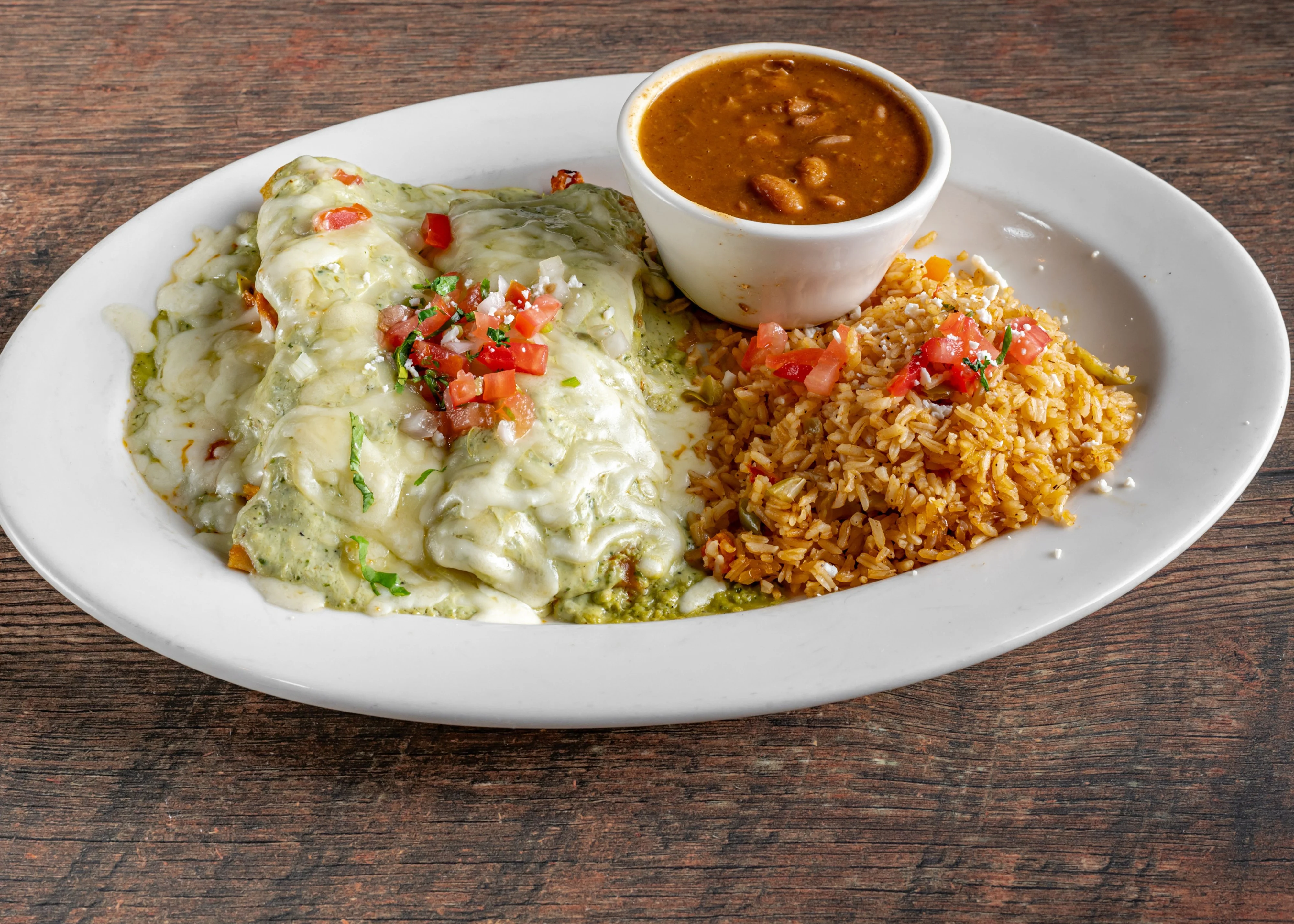 Plate of enchiladas verdes with rice and beans