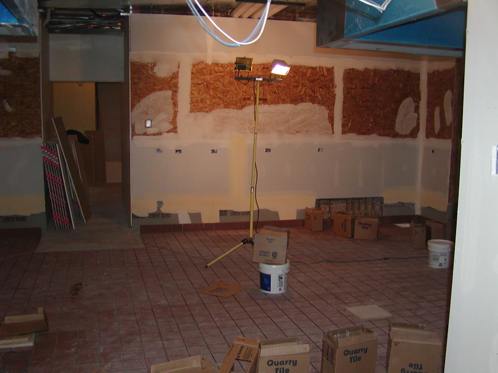 Under-construction restaurant interior with exposed walls and lighting setup