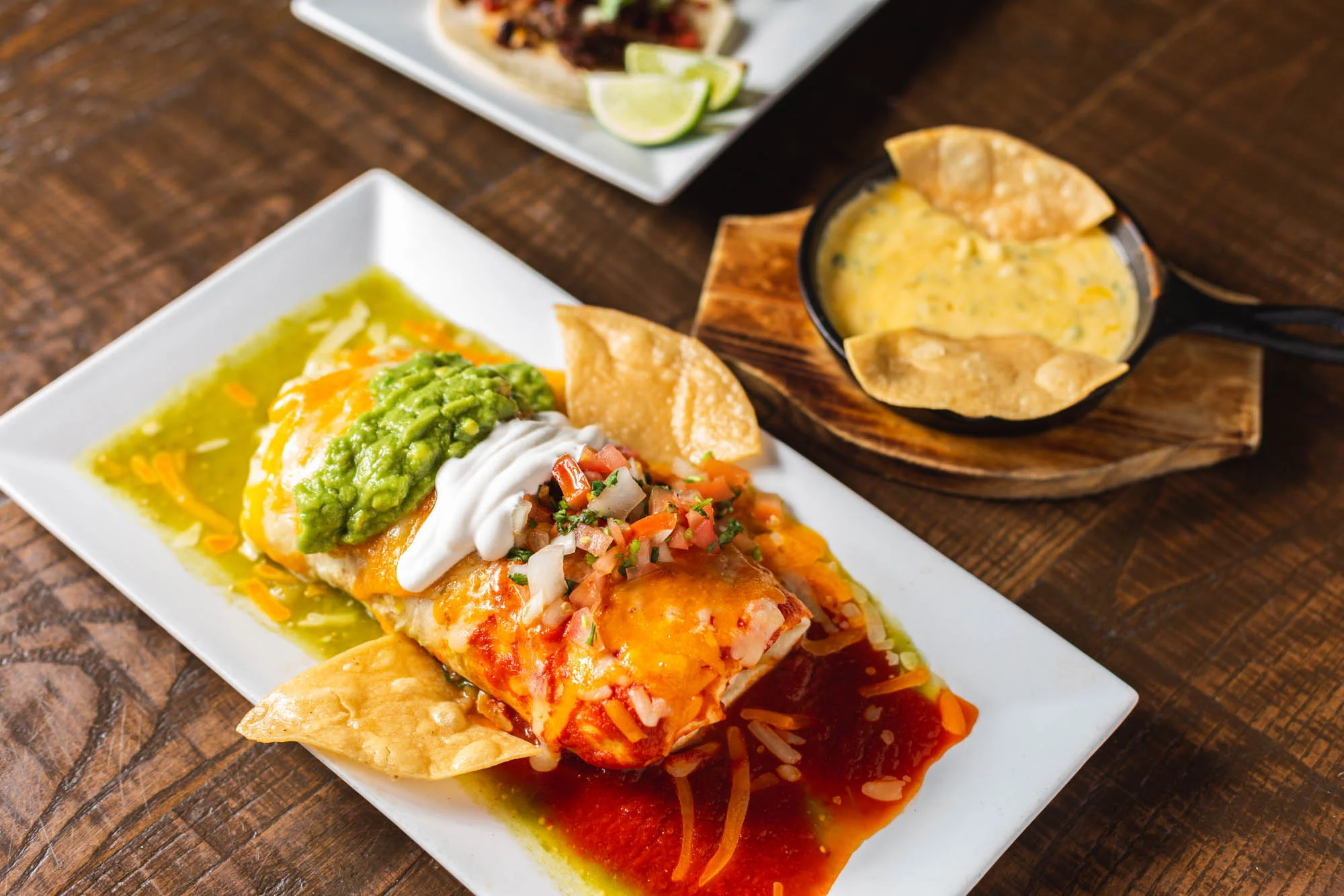 Mexican Flag Burrito - Choice of meat or vegetable, rice, beans, topped with green and red sauce, melted cheese, guacamole, pico de gallo and sour cream