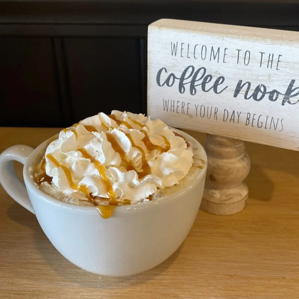 Caramel latte topped with whipped cream and caramel drizzle