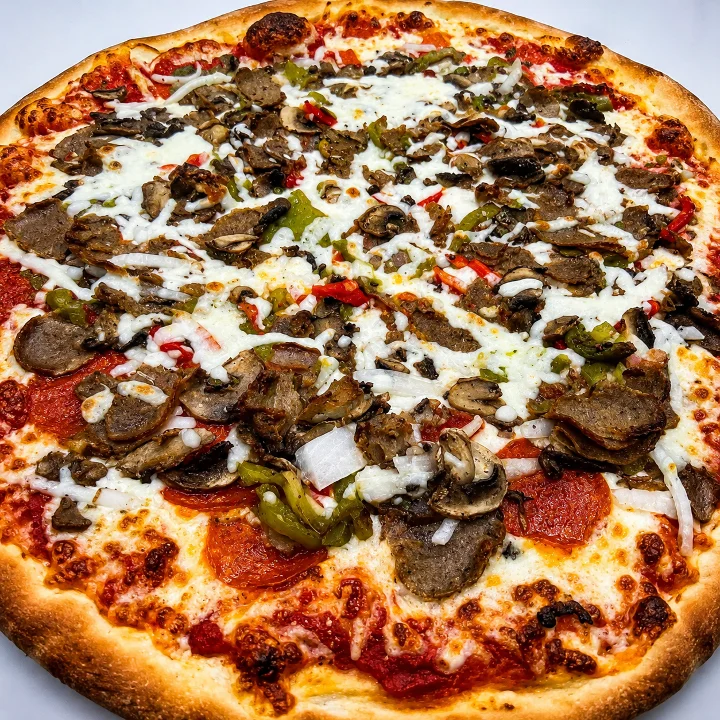 A hearty pizza featuring a variety of toppings including beef, pepperoni, green peppers, and mushrooms, all on a thick crust.
