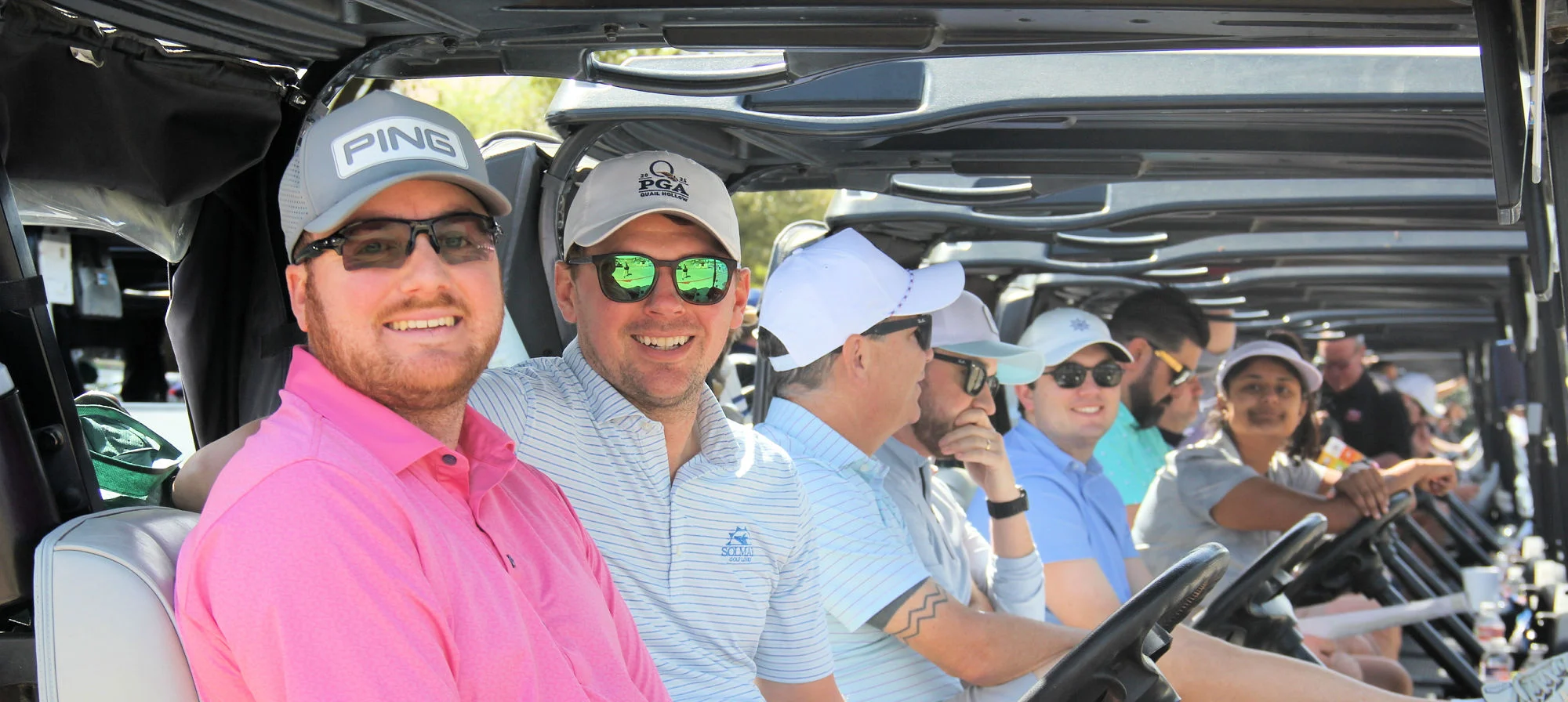 Smiling group enjoying a sunny golf cart outing