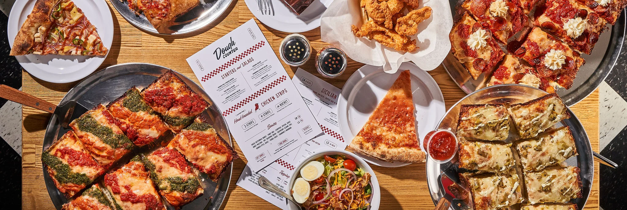 Sicilian pizza with chicken strips and salad in a casual dining setting
