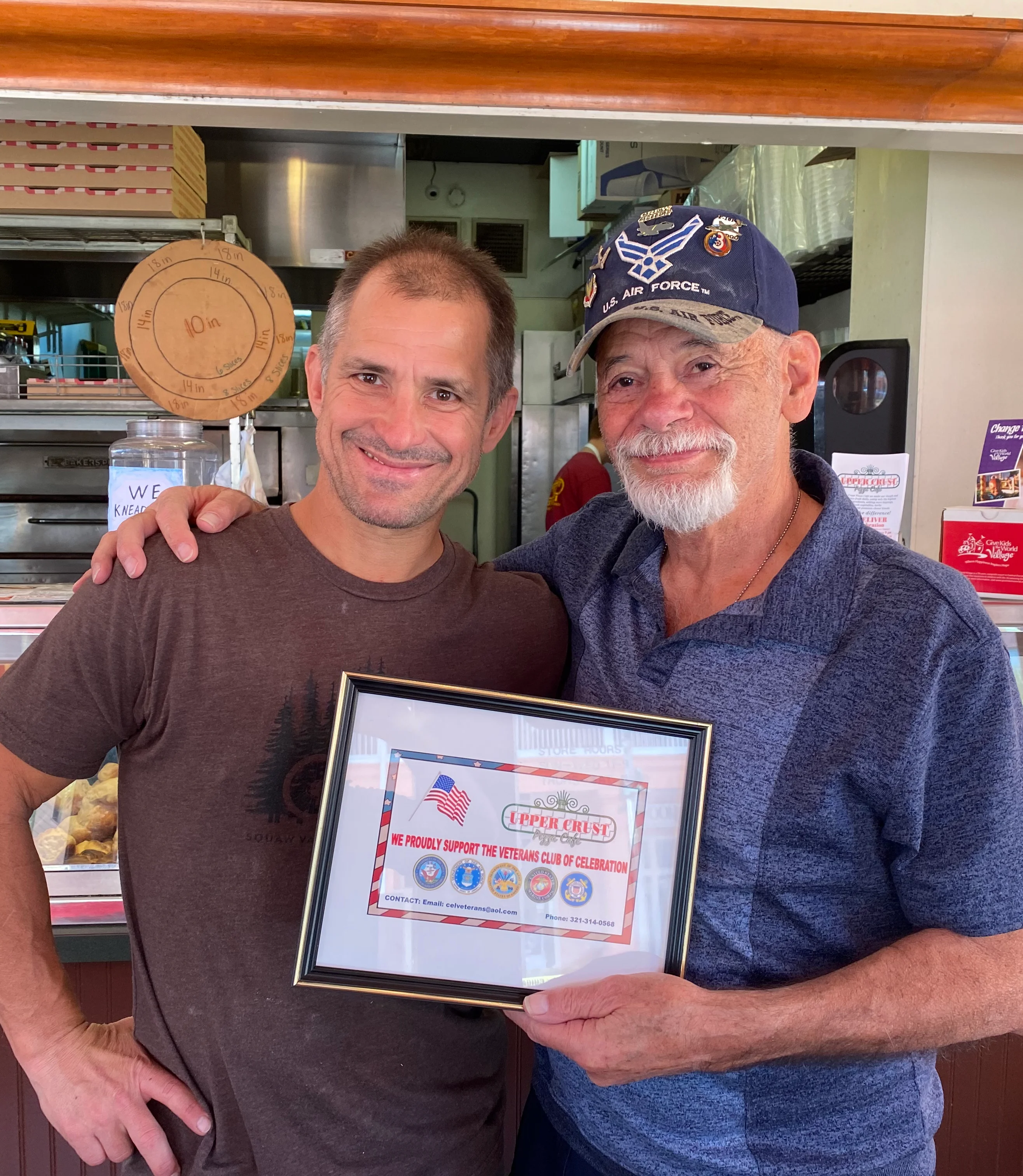 Two men celebrating a restaurant award in a cozy eatery