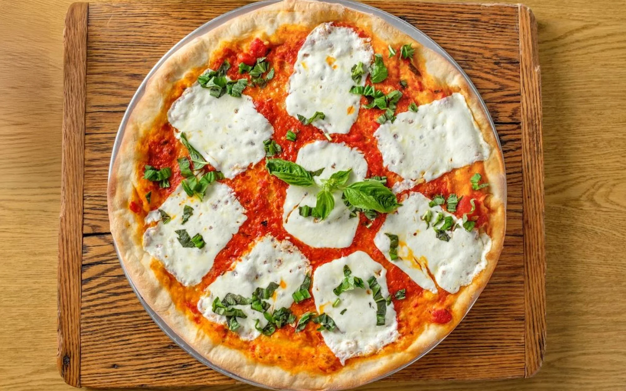 Margherita pizza topped with fresh basil and mozzarella