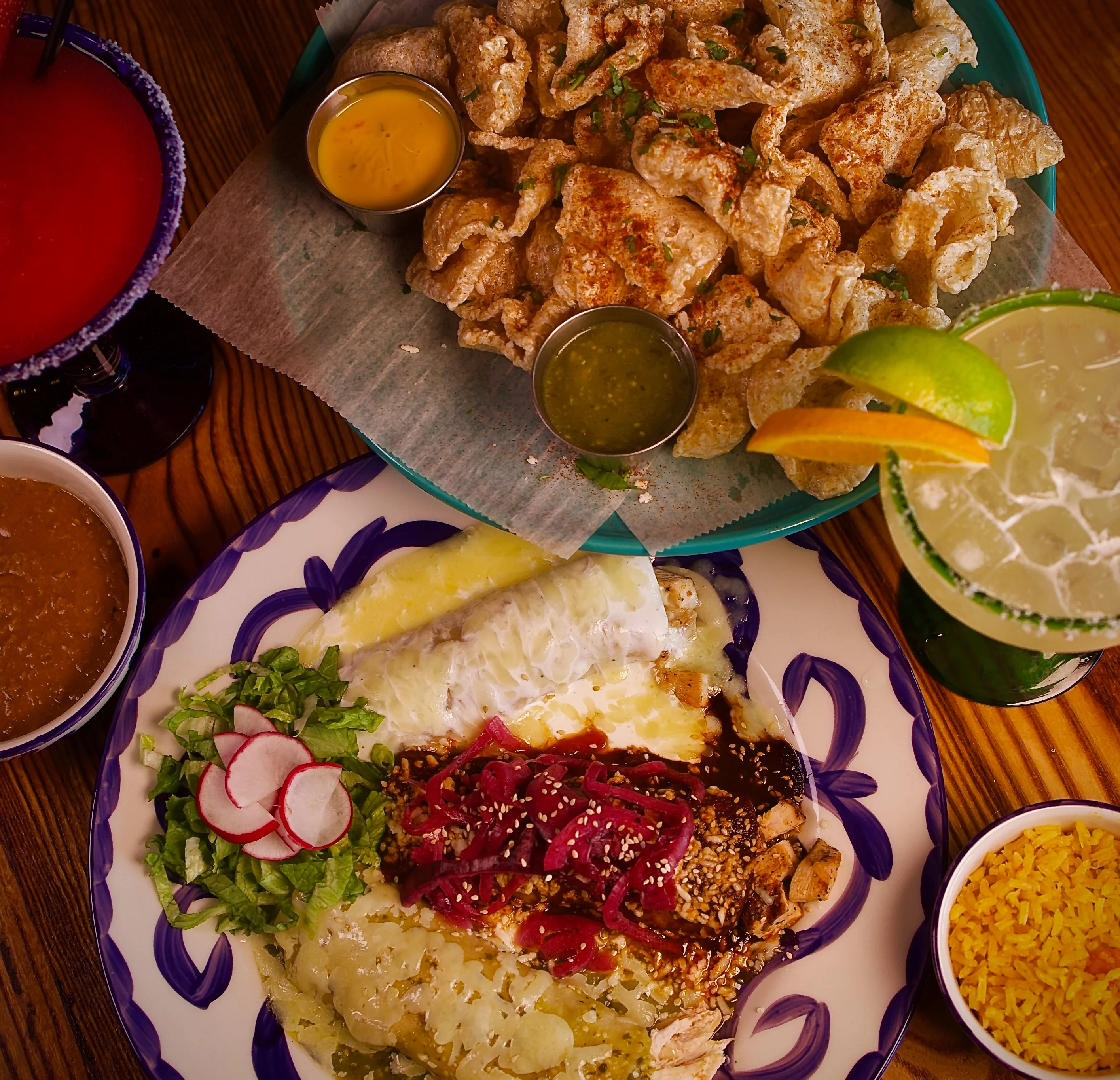Plate of enchiladas with sides in a vibrant Mexican restaurant setting