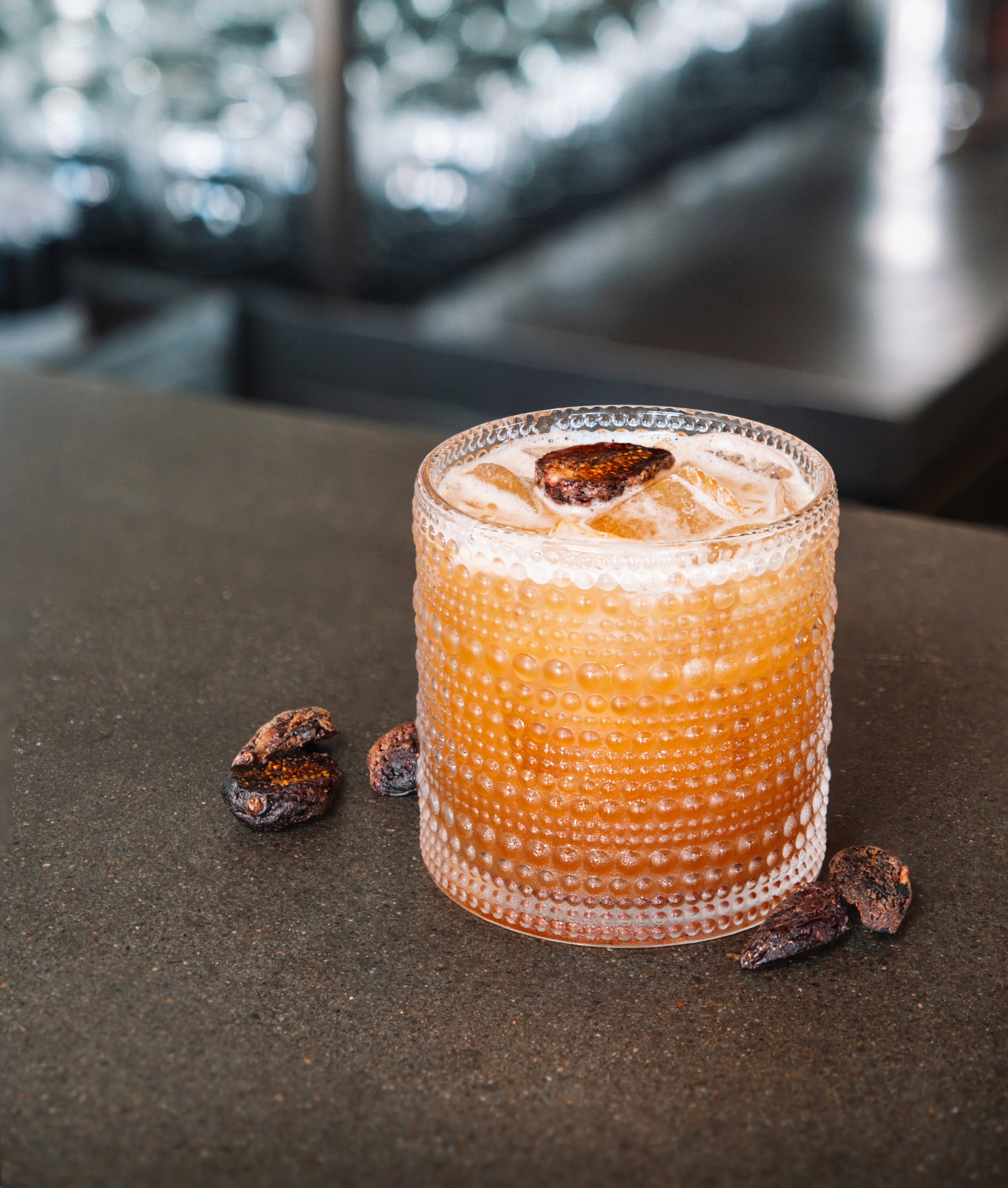 Craft cocktail served in a textured glass at a modern bar