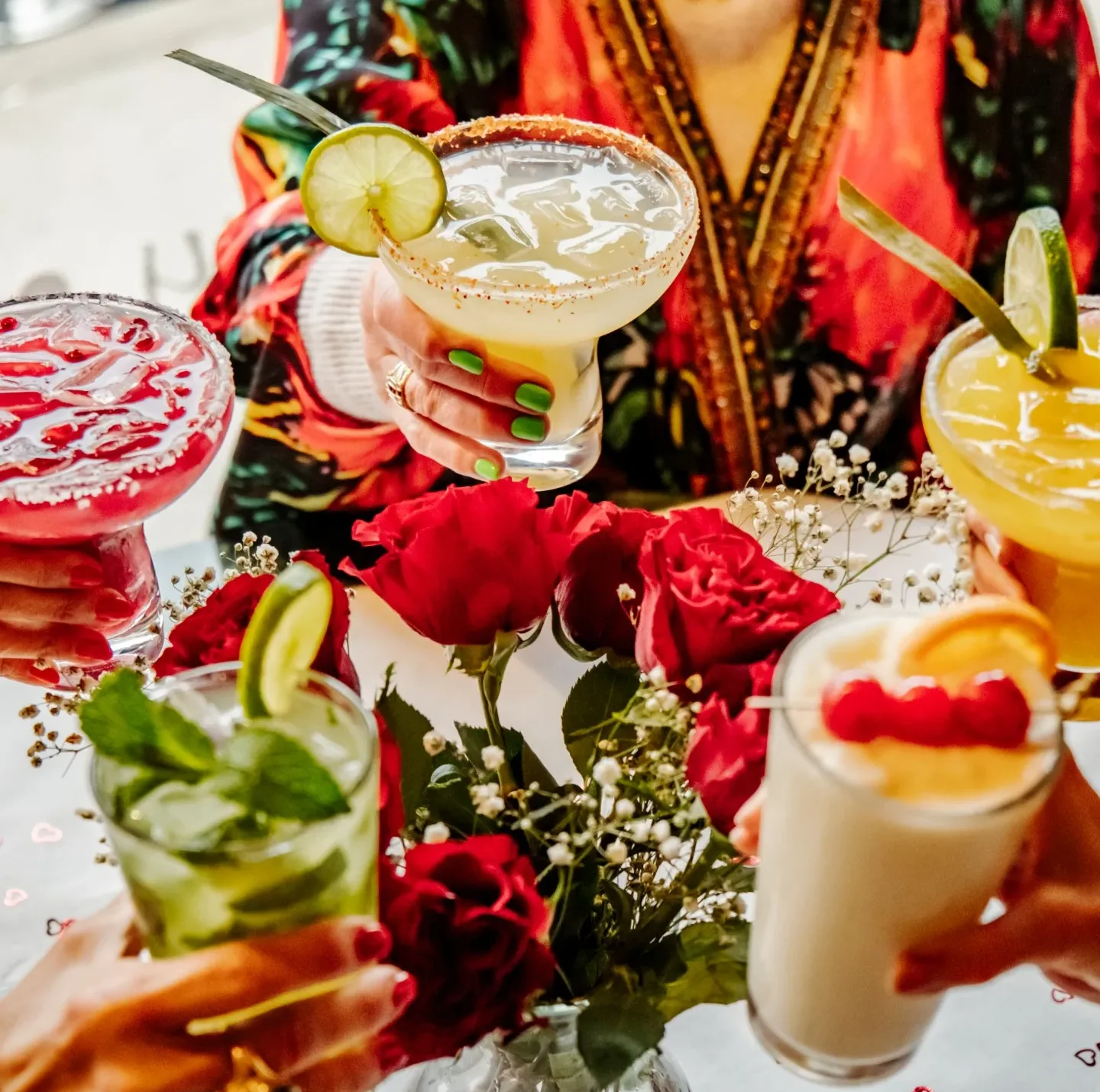 Colorful cocktails with roses on a festive table