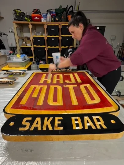 Sign for Haji restaurant featuring vibrant epoxy design.