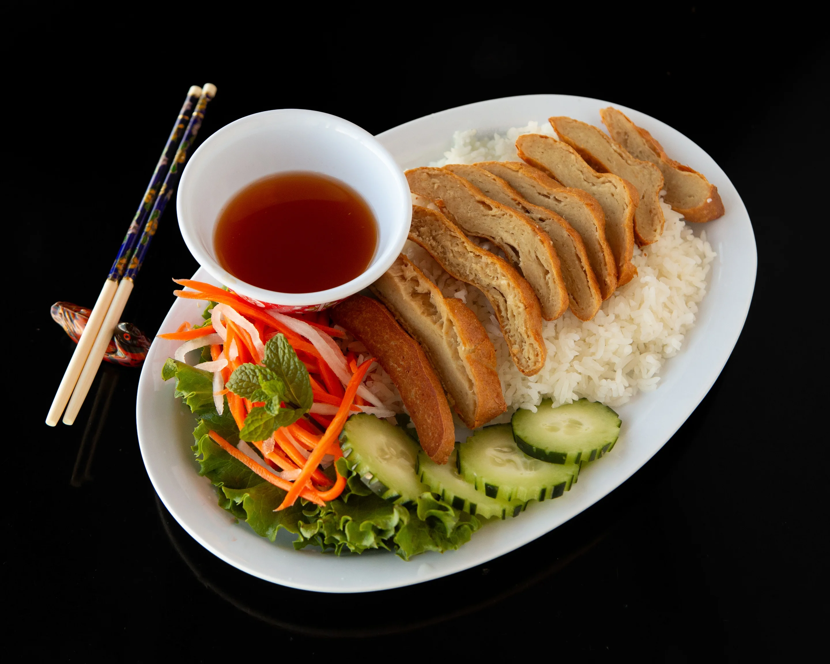 Vietnamese rice plate with fried tofu and fresh vegetables