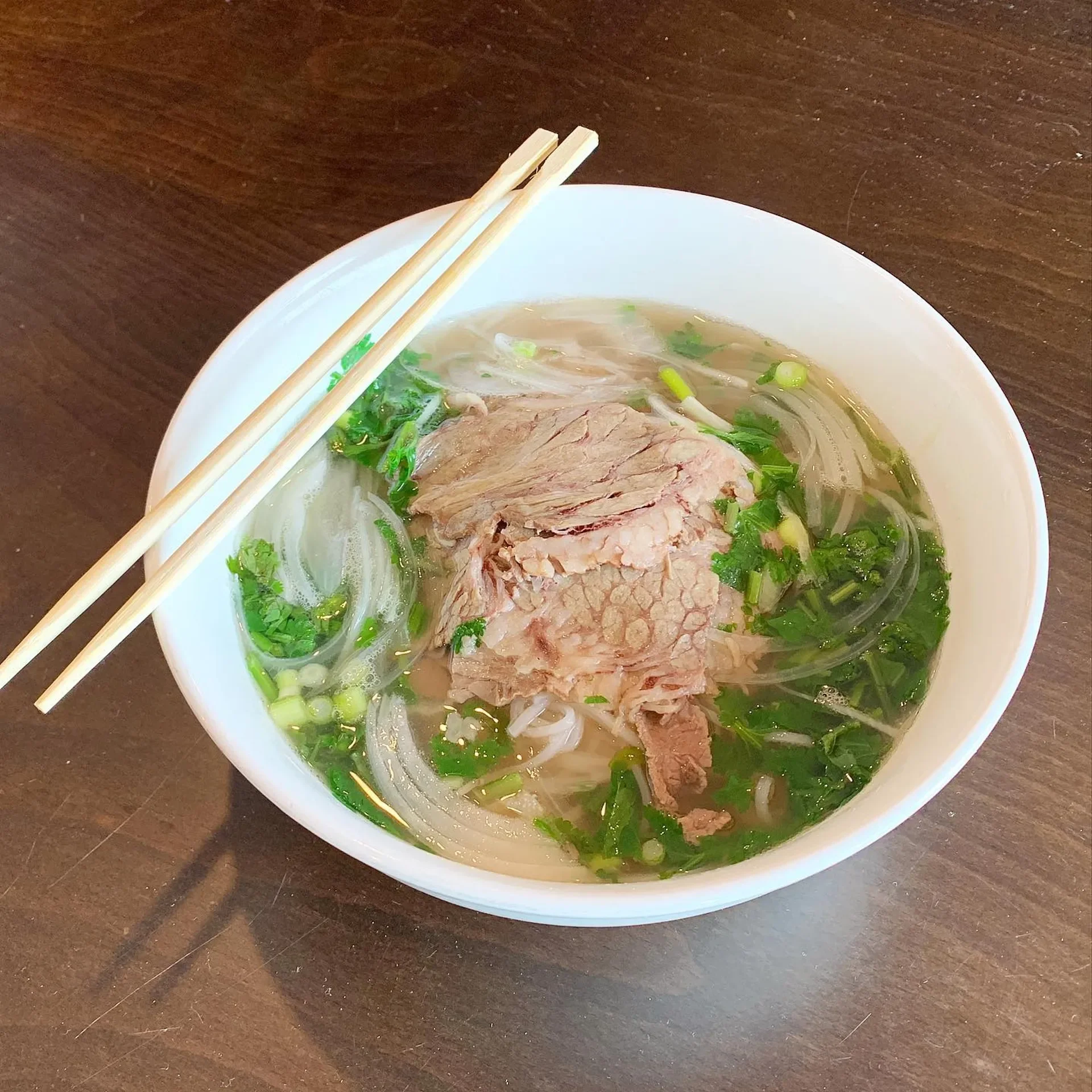Bowl of Vietnamese pho with tender beef and fresh herbs