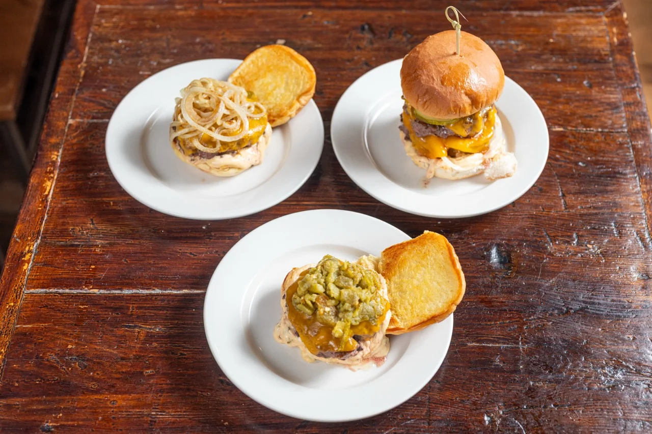 Gourmet cheeseburgers on white plates