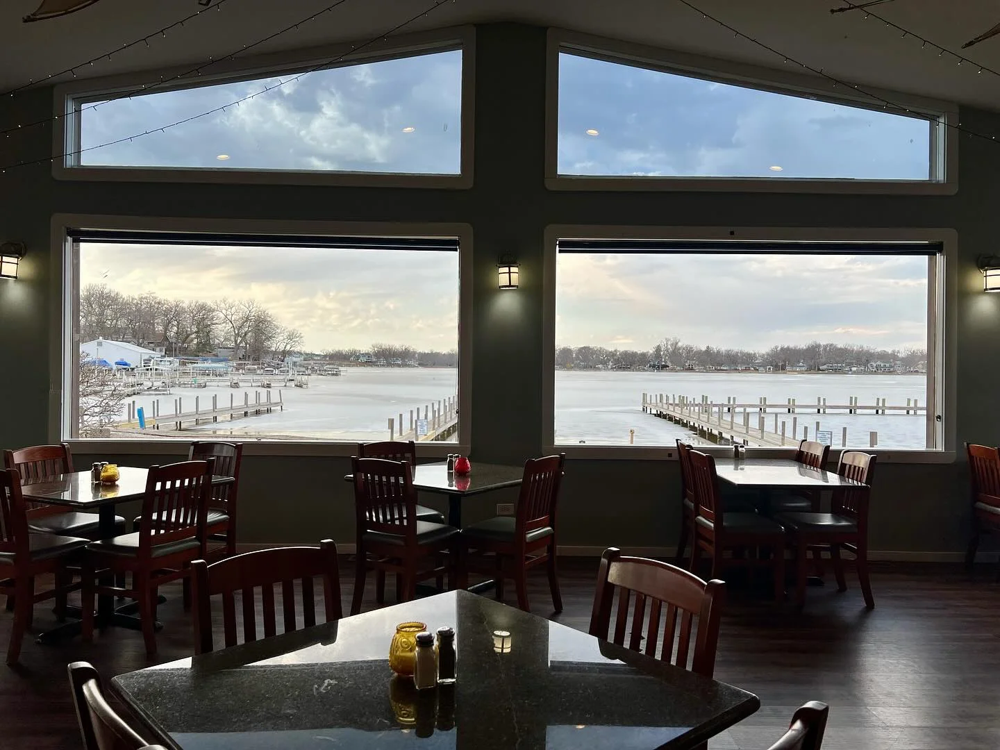 Cozy restaurant interior with lake view and wooden tables