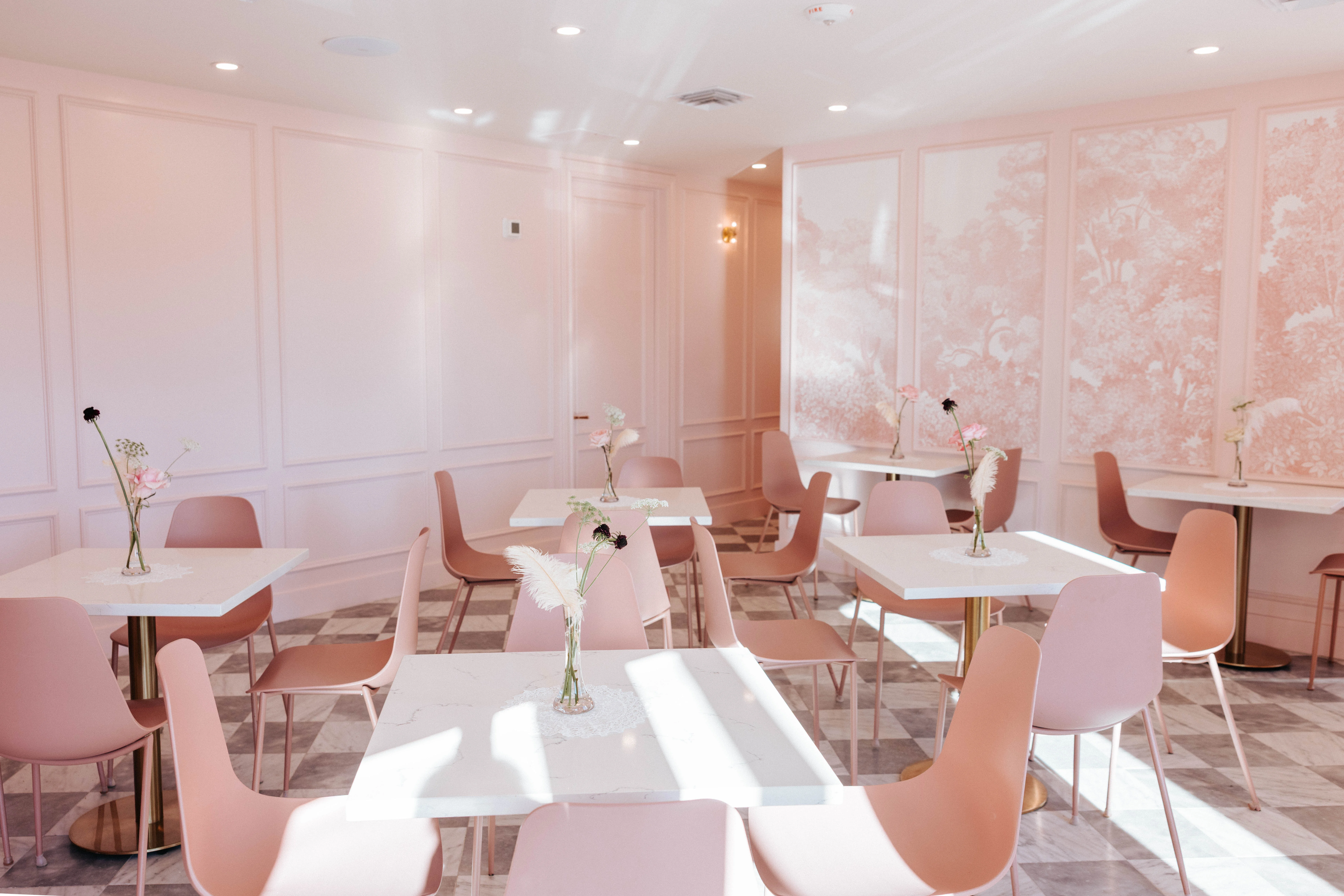 Chic restaurant interior with pink decor and elegant tables