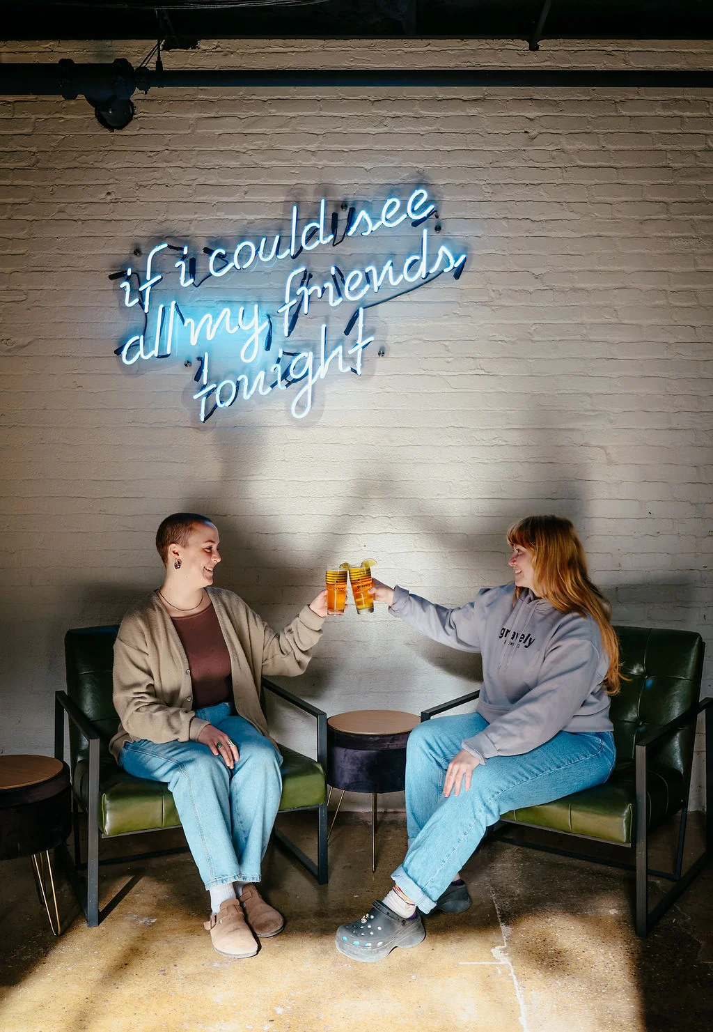 Gravely Brewing cheers in front of neon LCD Soundsystem event