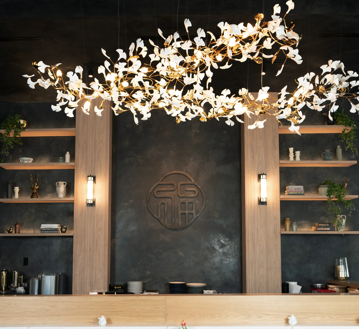 Elegant restaurant interior featuring artistic lighting and wooden shelves.