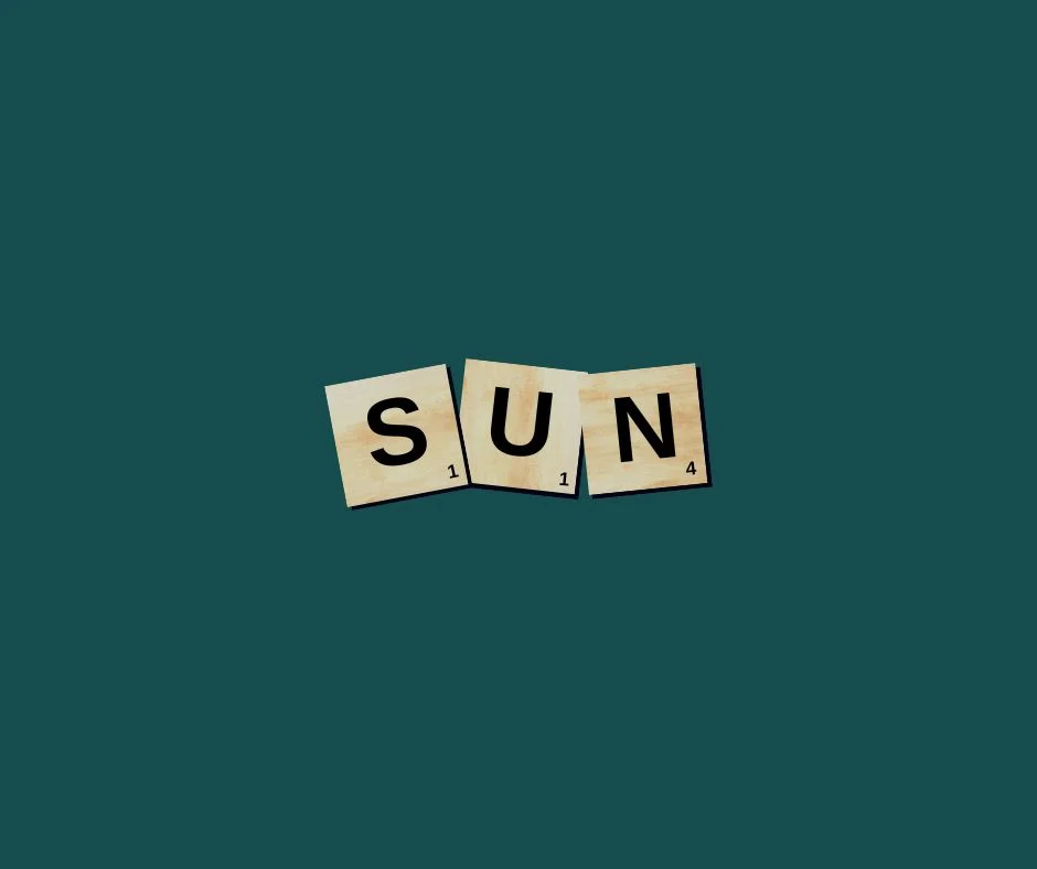 Scrabble tiles spelling 'SUN' on a teal background