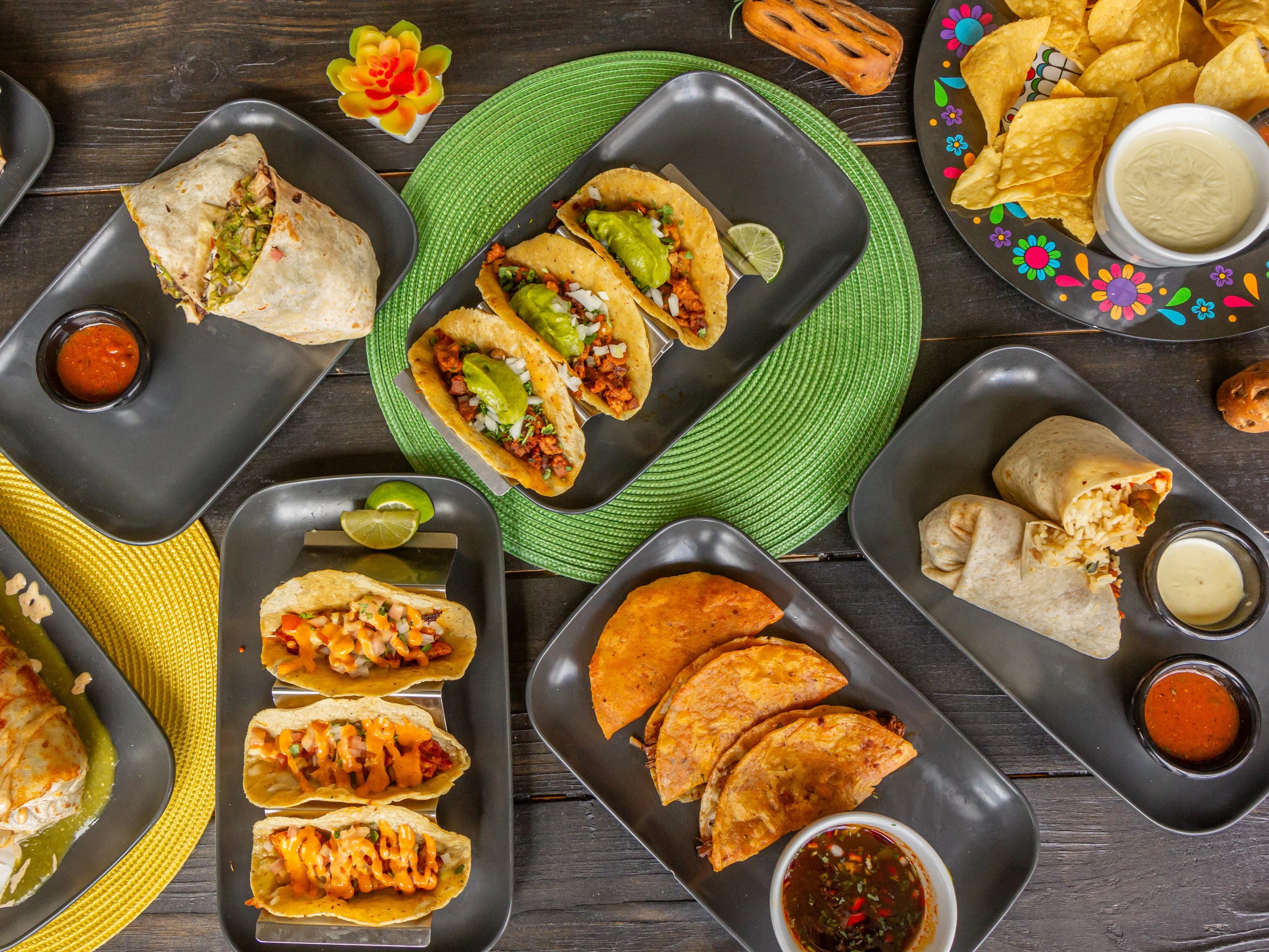 Assorted Mexican tacos and burritos on a vibrant table