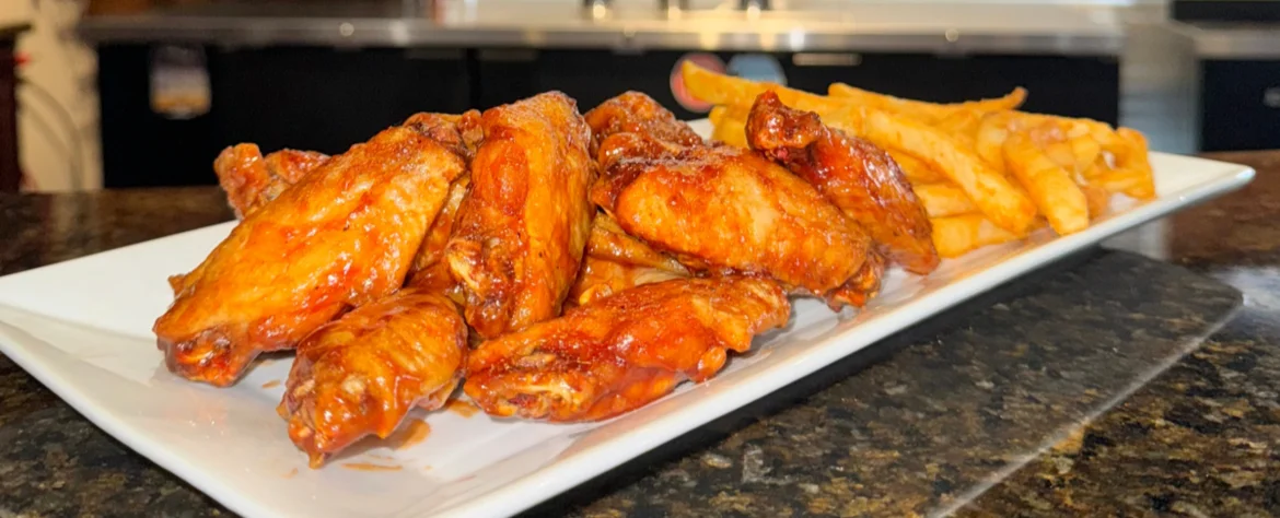Crispy buffalo chicken wings with fries