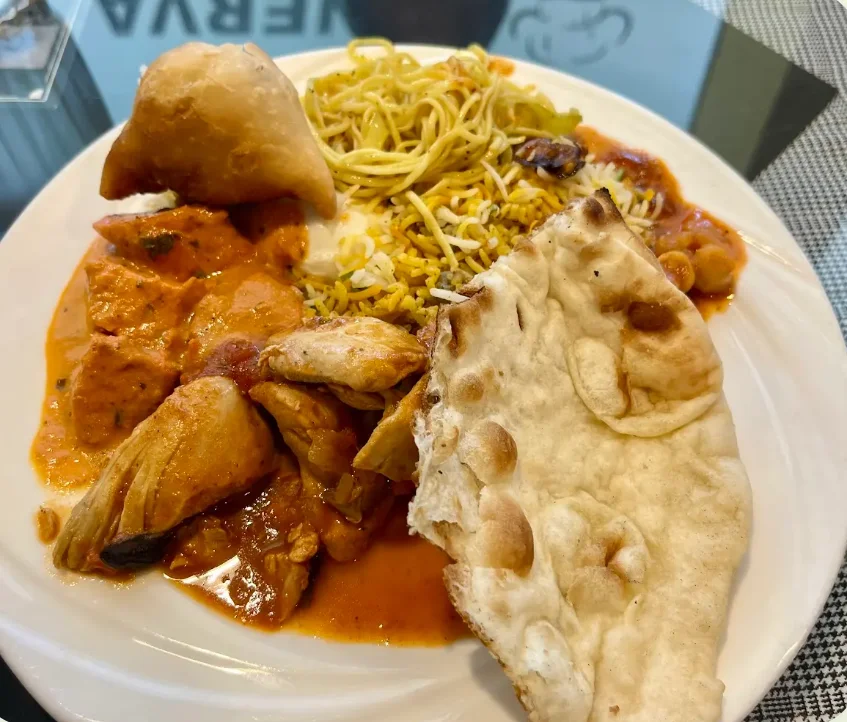 Plate of Indian chicken curry with naan and fried rice