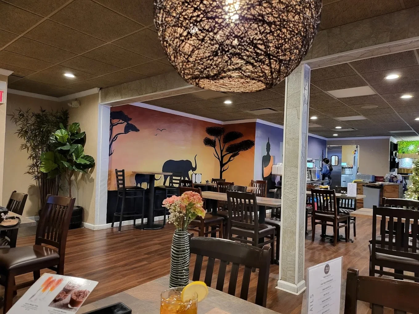 Cozy restaurant interior with artistic elephant mural and warm lighting
