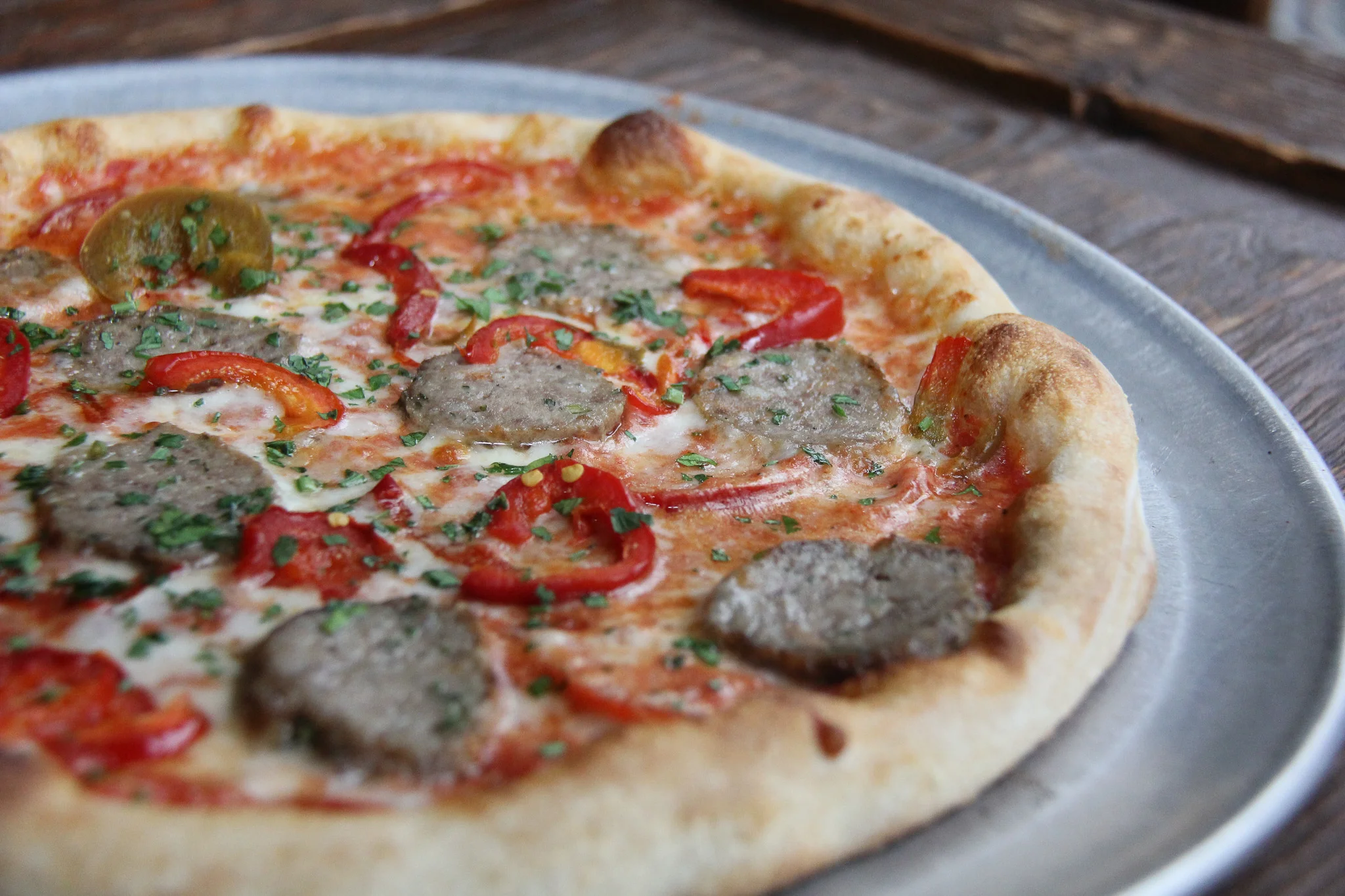 Italian sausage pizza with red peppers and herbs