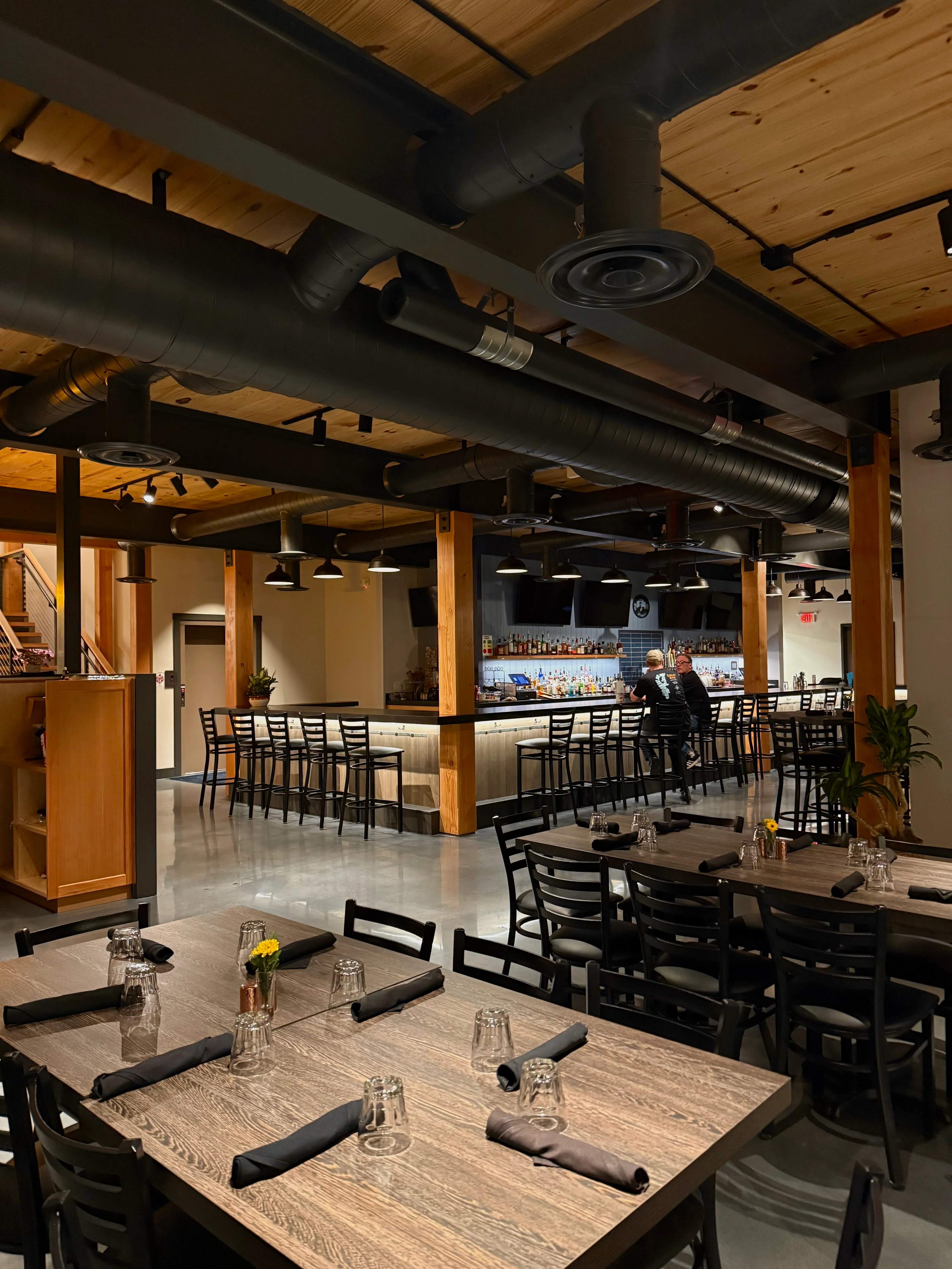Modern restaurant interior with wooden accents and bar seating