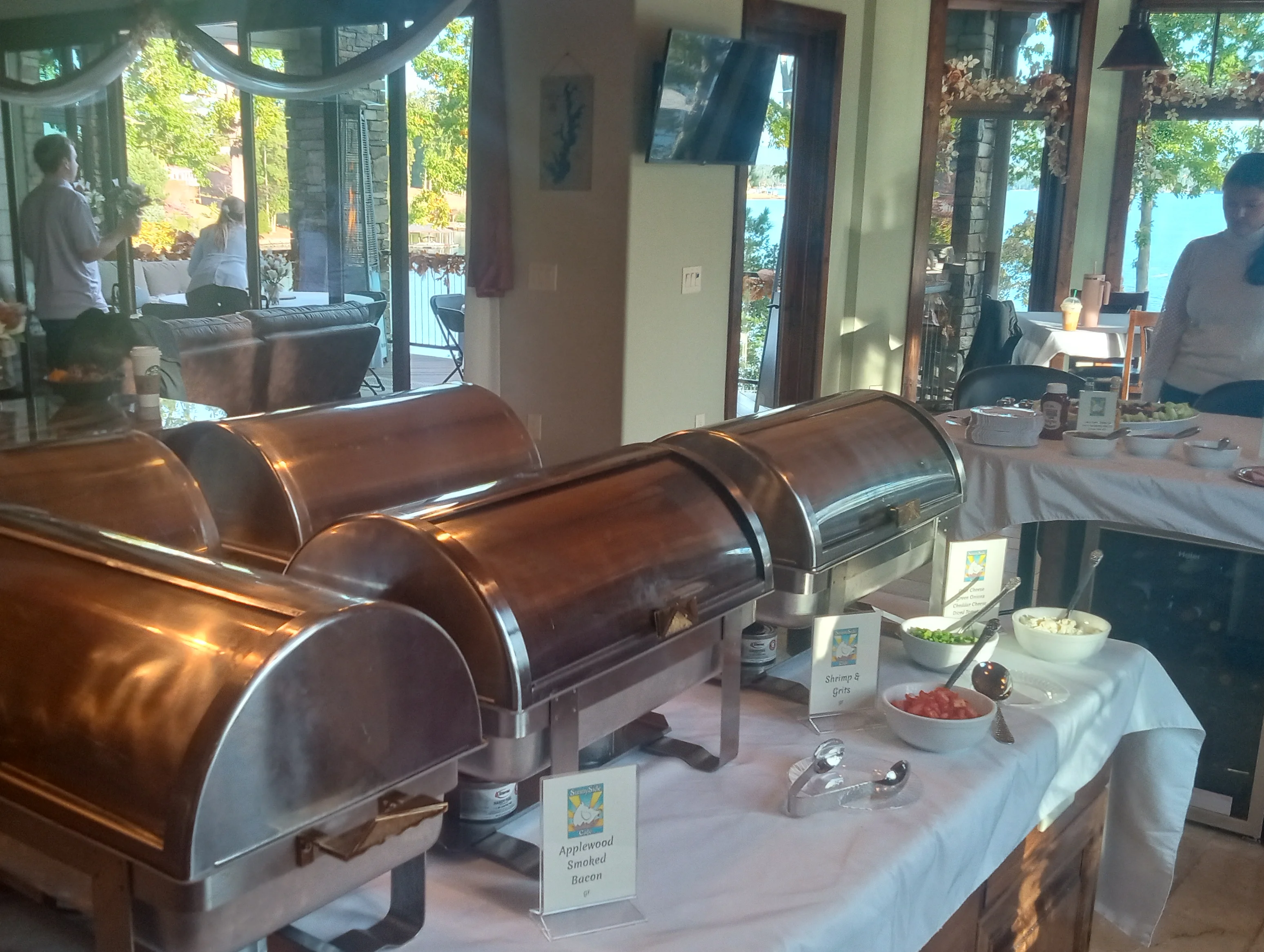 Buffet setup with chafing dishes and toppings in a scenic dining area.