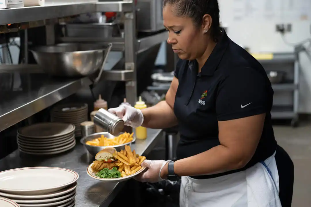 Cook preparing a Cajun fried fish po boy