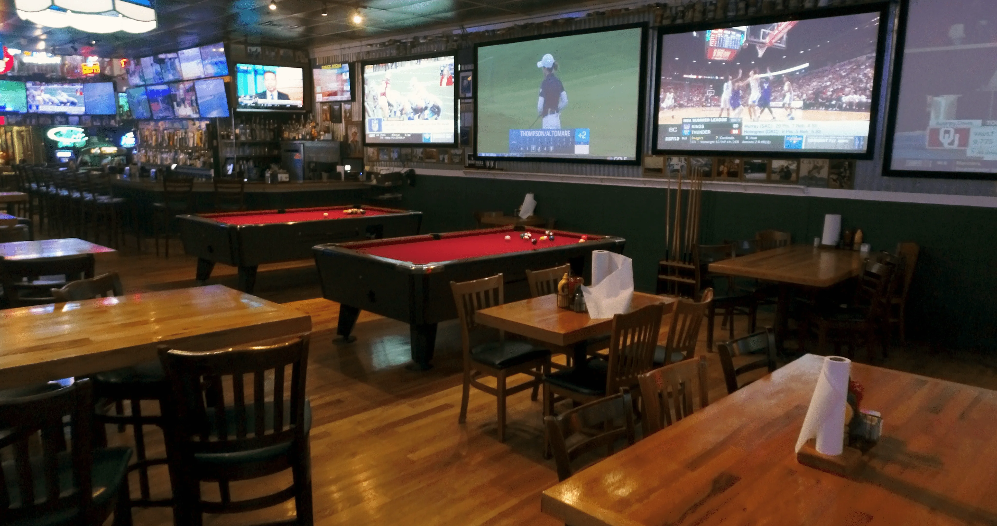 Cozy sports bar interior with pool tables and multiple TVs
