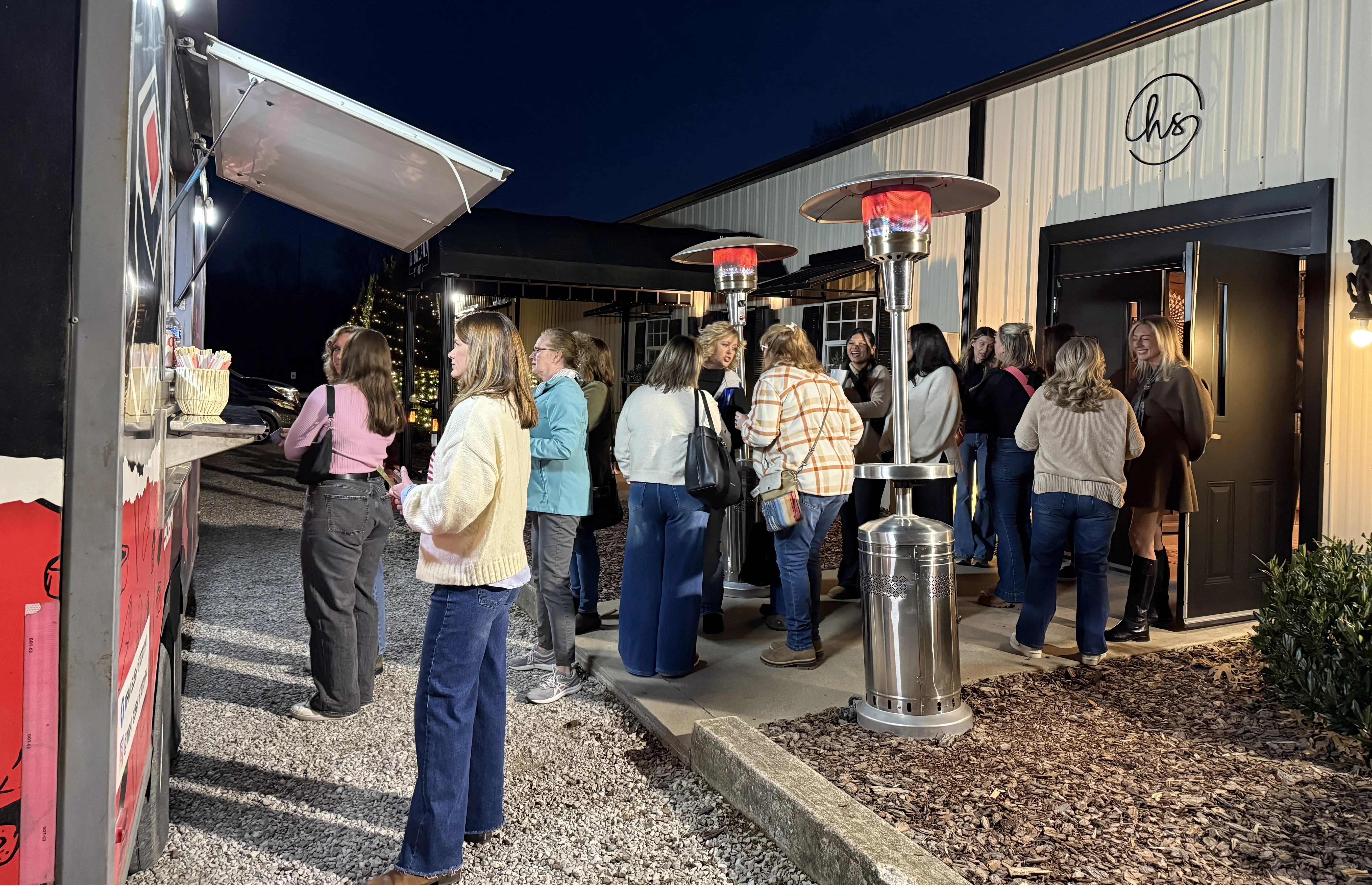 Crowd enjoying food truck offerings on a cozy evening
