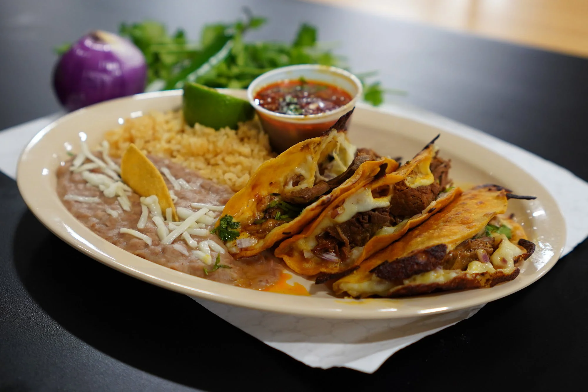Plate of Mexican tacos with rice and beans