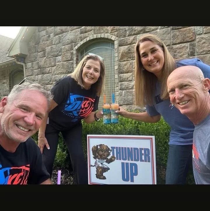 Group of friends celebrating with drinks and a 'Thunder Up' sign