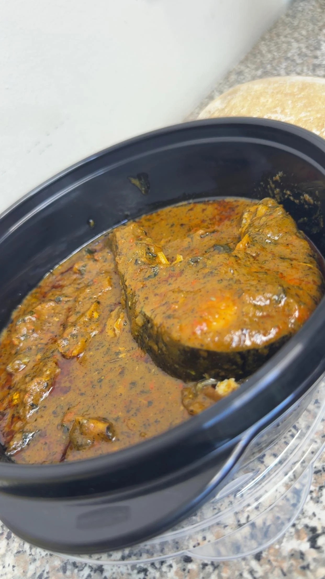 Nigerian egusi soup served in a black bowl
