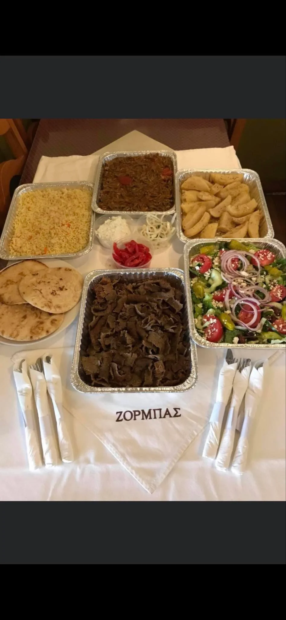 Platter of Greek gyros with rice, salad, and pita bread