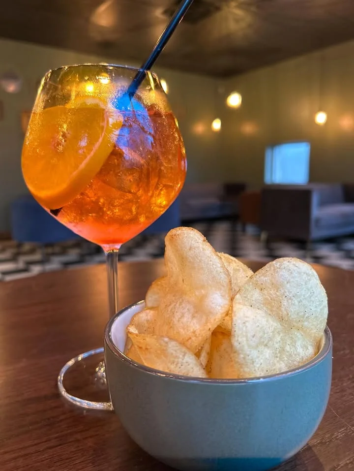 Refreshing cocktail with orange slice and crispy potato chips