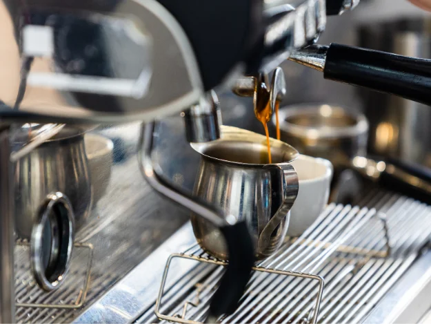 Espresso pouring from a coffee machine into a cup