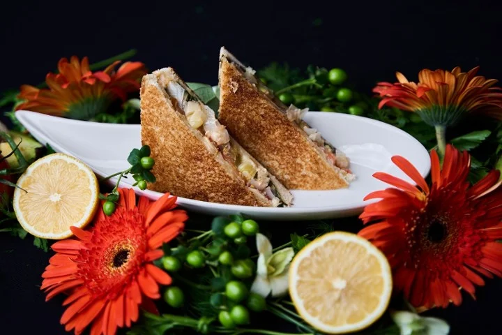 Classic sandwich with fresh ingredients and vibrant floral presentation