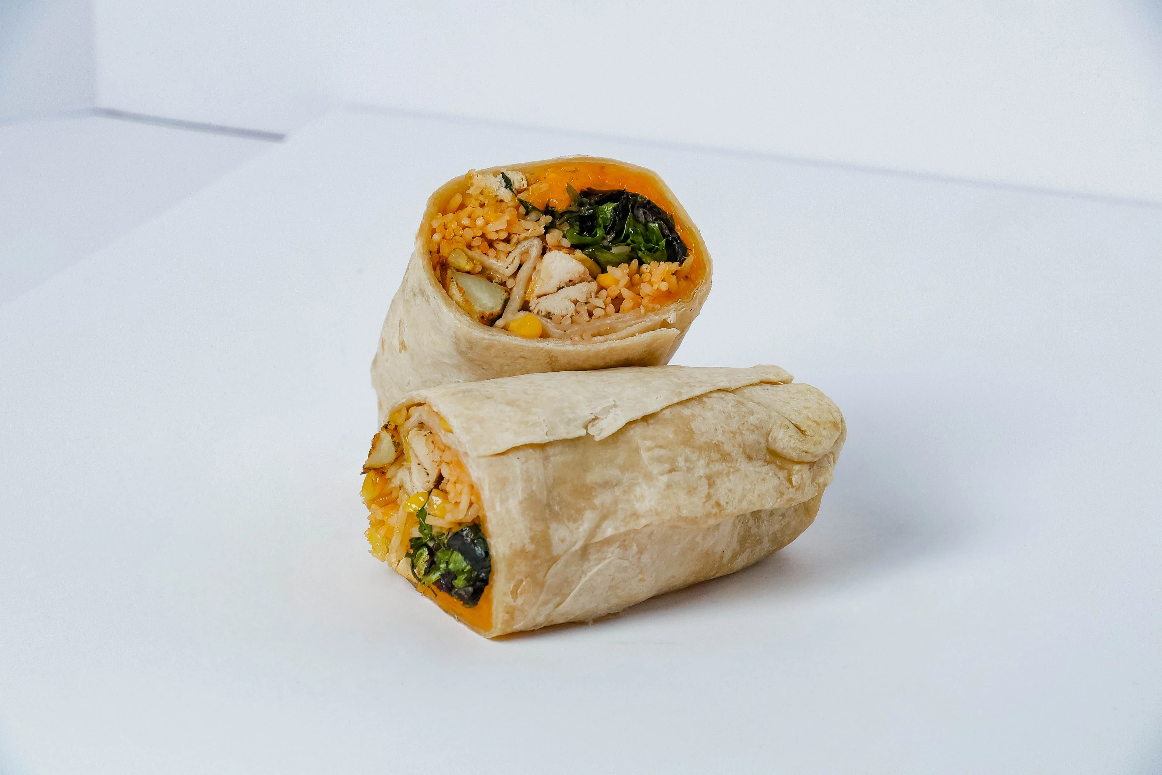 Delicious burrito filled with fresh ingredients on a wooden table.