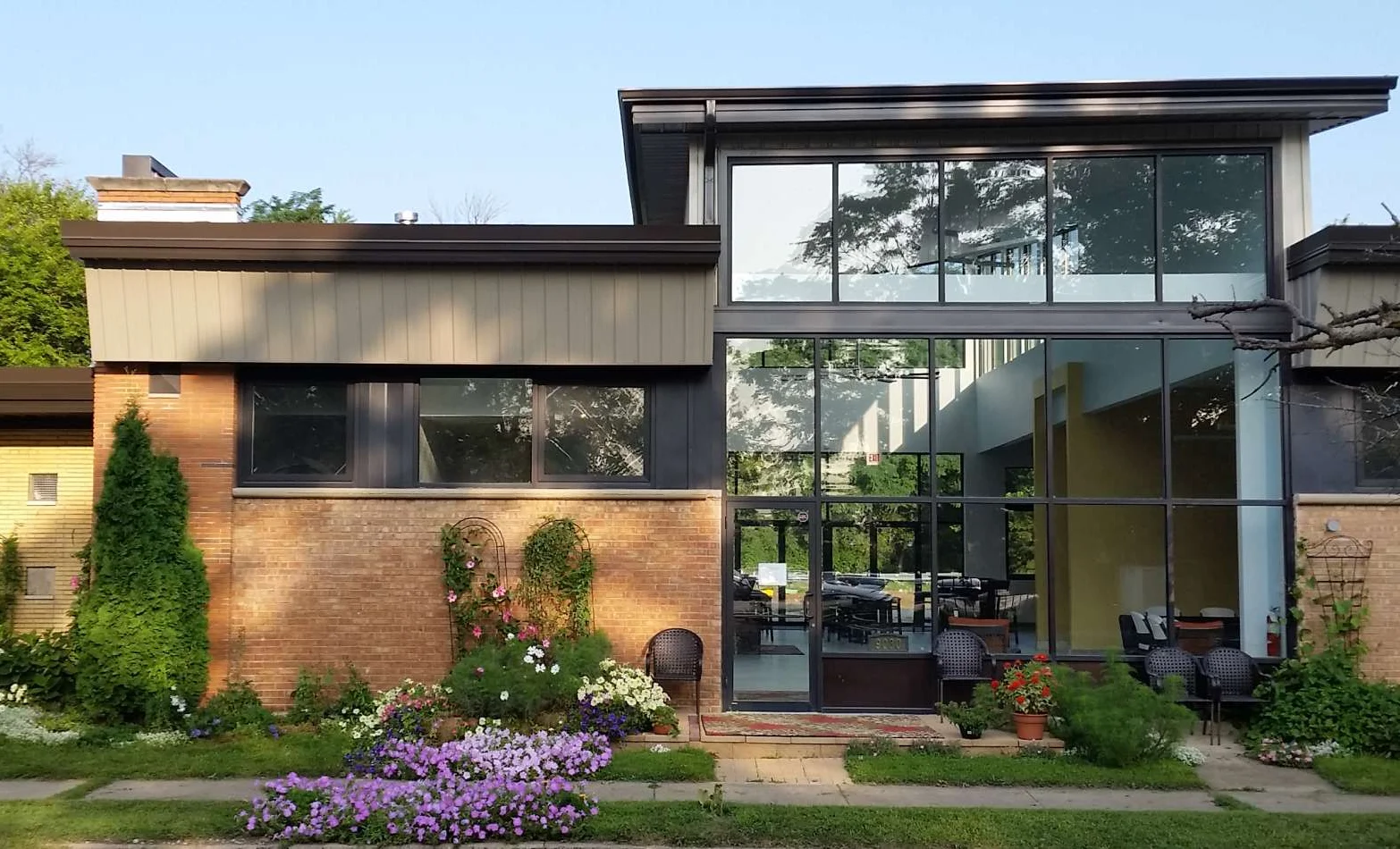 Modern restaurant exterior with vibrant flowers and large glass windows