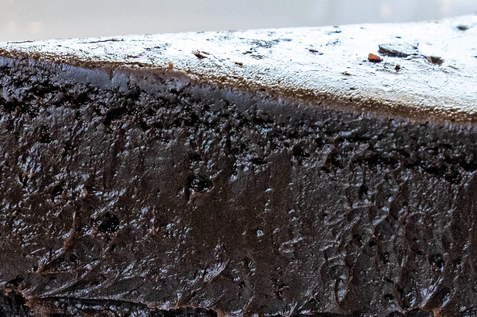 Decadent chocolate fudge cake slice on a black plate