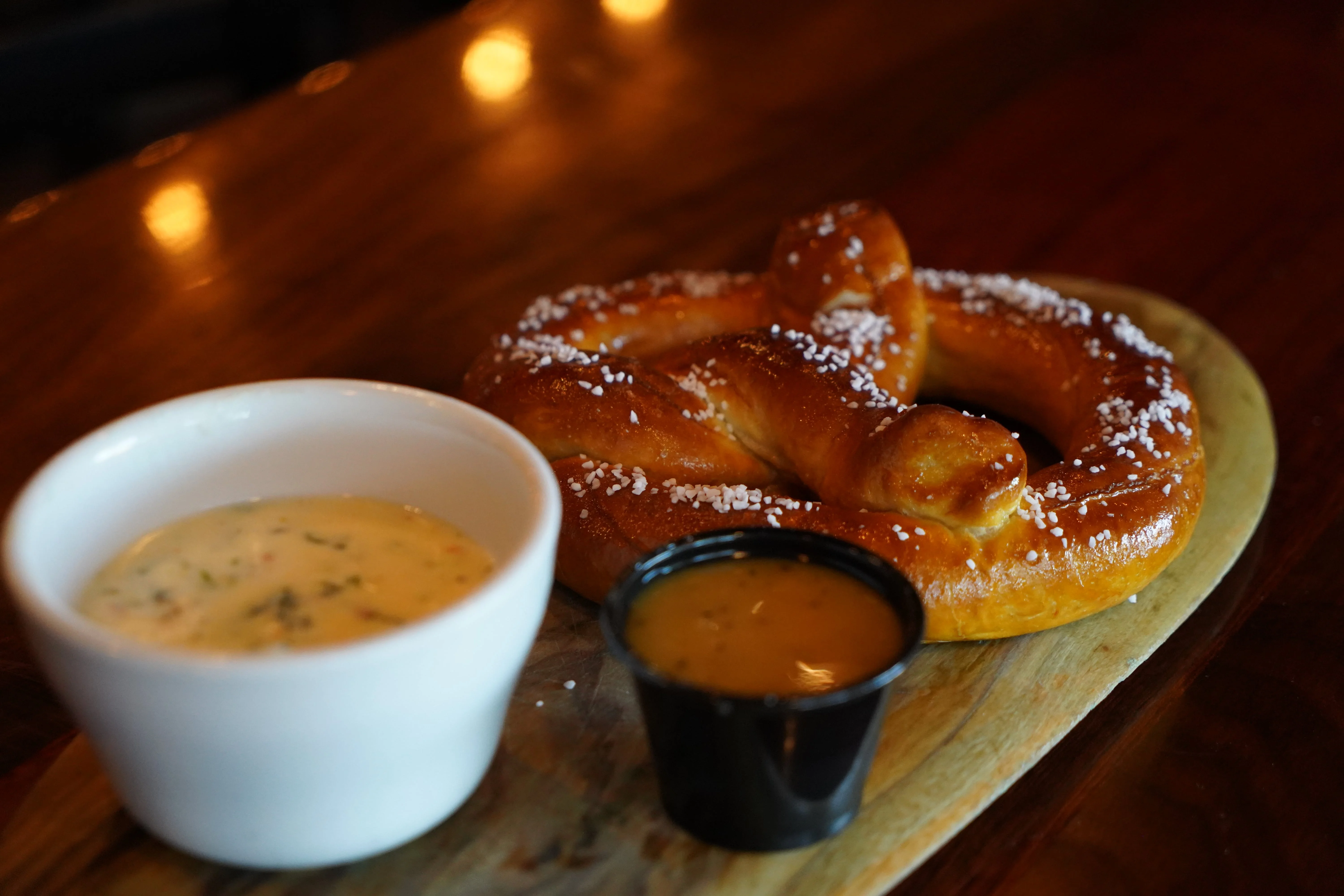 Soft pretzel served with cheese dip and mustard