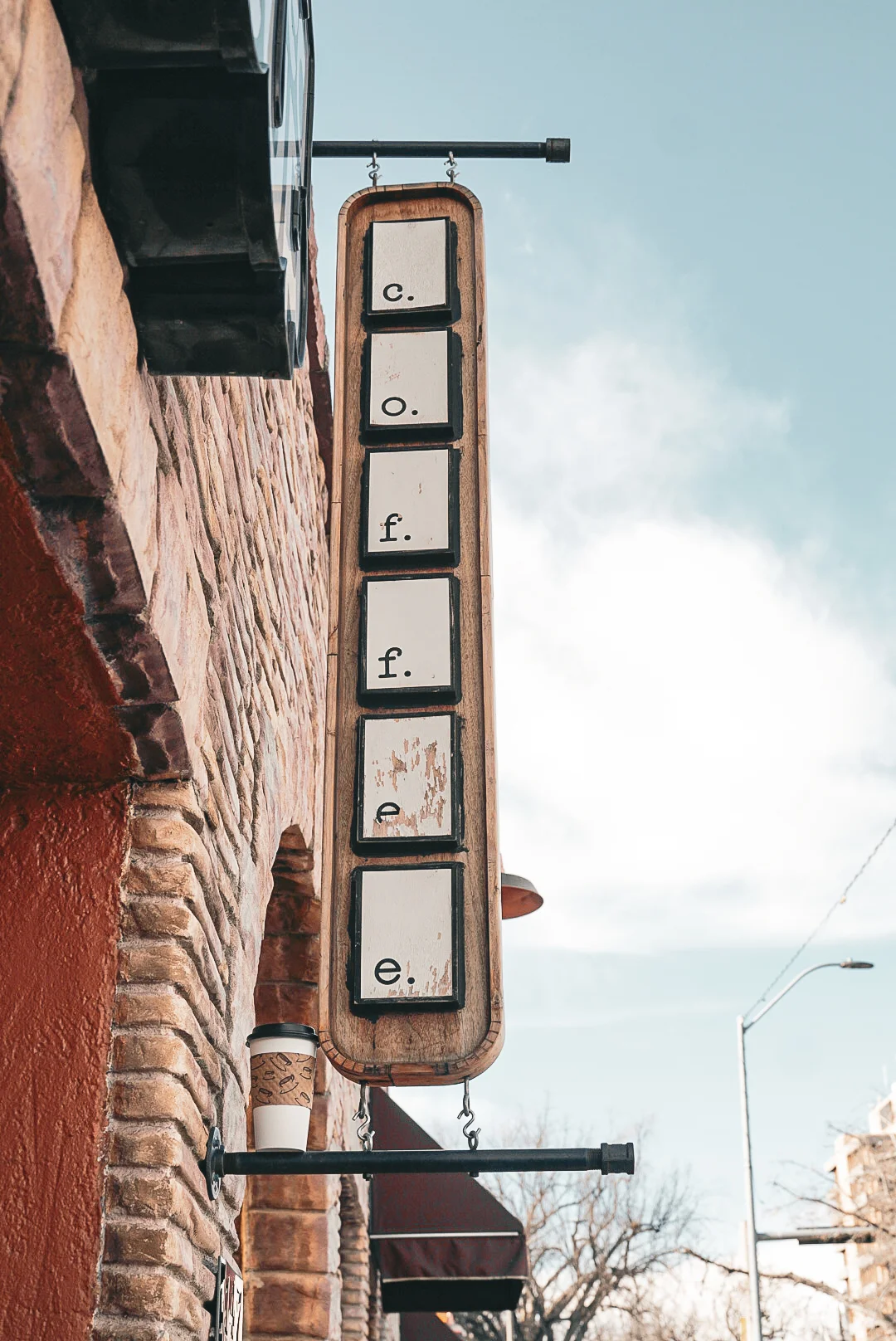 Coffee shop sign with rustic charm and blue sky backdrop