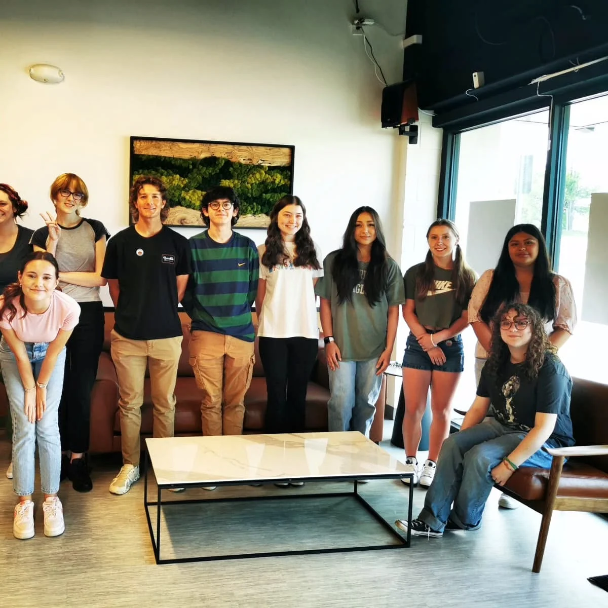 Group of young people posing in a modern cafe setting