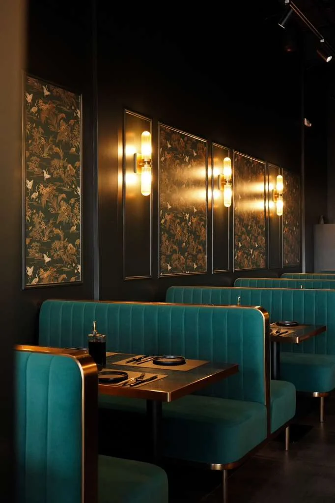 Stylish restaurant interior with teal booths and floral wallpaper