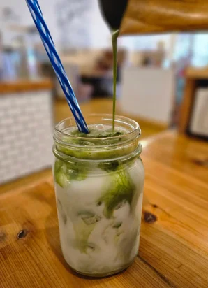 Iced matcha latte in a mason jar with blue straw